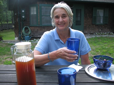 woman holding a glass of switchel, a refreshing summer drink