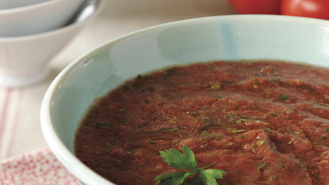 fresh gazpacho soup made with tomatoes onions peppers and bread with a cilantro garnish