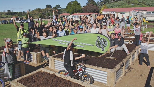 Children cheer on top of raised garden beds