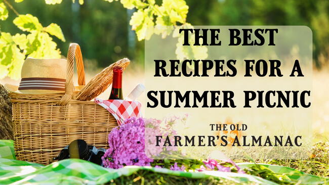 The best recipes for a summer picnic. picnic basket on a blanket with a hat and bottle of wine