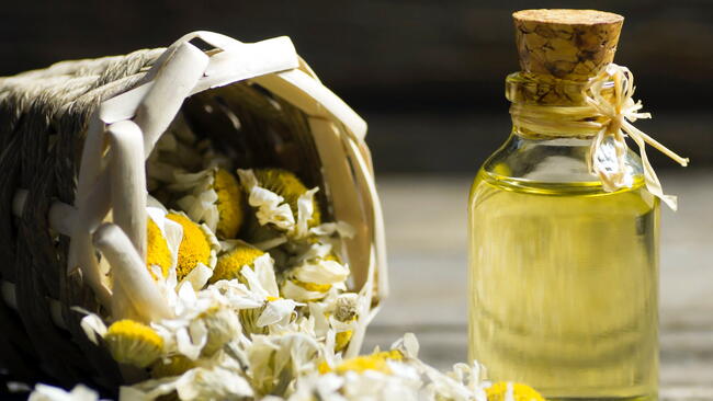 chamomile toner in a bottle with a paper bag of chamomile next to it