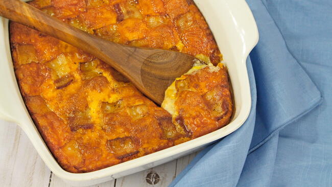 corn pudding with wooden spoon