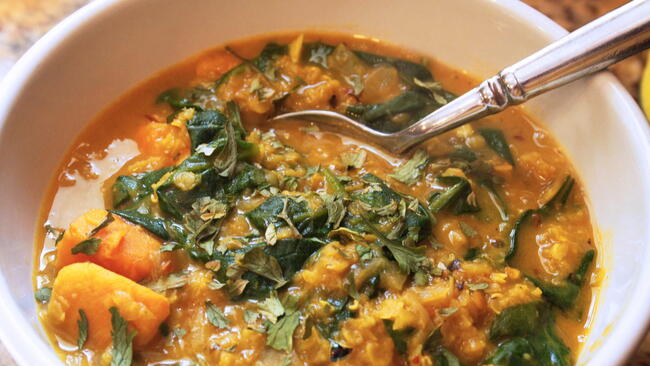Red Lentil Curry with Sweet Potato and Spinach in a Bowl with a Spoon