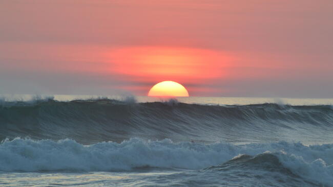 ocean waves with the setting sun
