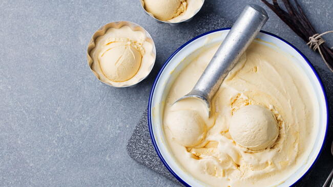 Homemade vanilla, caramel ice cream in vintage bowl Organic product on a grey stone background