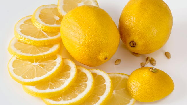 Lemons, lemon slices, and lemon seeds on a white table