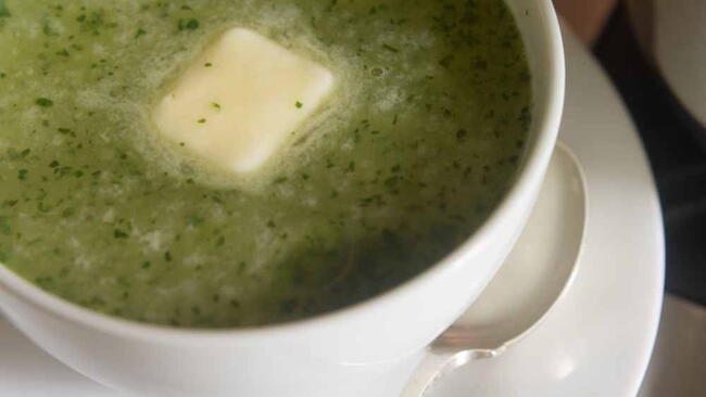 Butter in center of bowl of lettuce soup