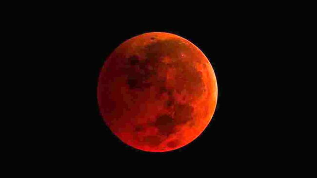 A deep red Moon during a total lunar eclipse, commonly called a Blood Moon.