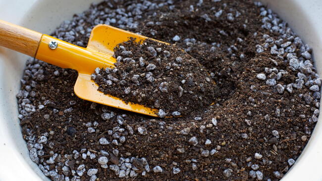 potting mix with perlite and a yellow shovel
