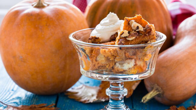 bowl of pumpkin bread pudding with pumpkins and squash