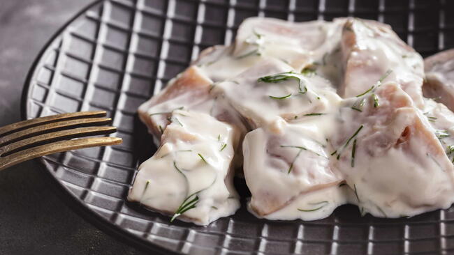 Pickled herring in cream sauce with dill.