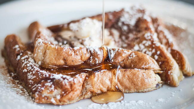 French Toast with Syrup and powdered sugar on a white plate