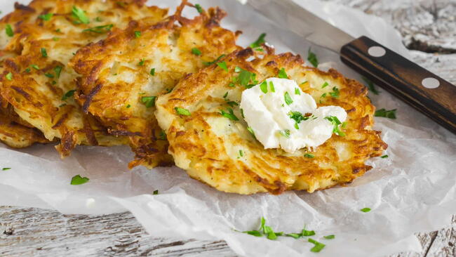 Potato pancakes or latkes on a light rustic wood surface