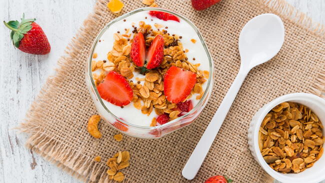Yogurt topped with strawberries and granola 