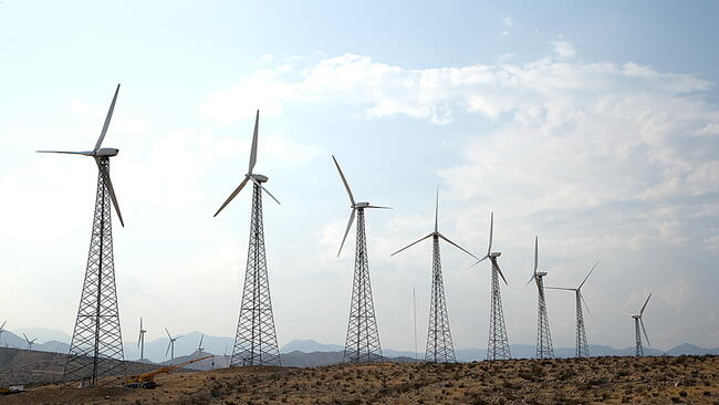 windmills in an open field with a blue sky