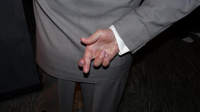 fingers crossed behind a man's back
