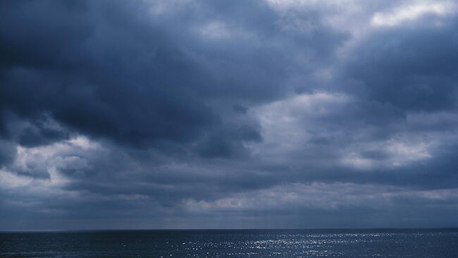 cloudy skies over still water