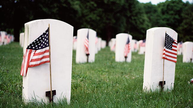 graves with flags beside them for Memorial Day