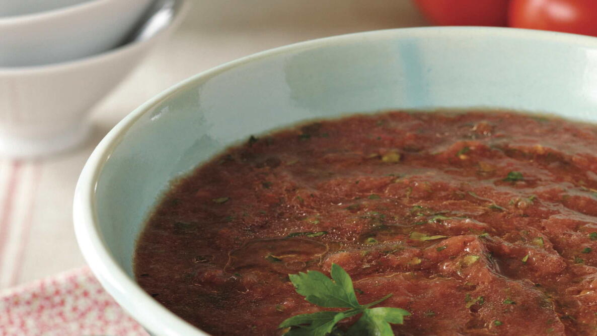 fresh gazpacho soup made with tomatoes onions peppers and bread with a cilantro garnish