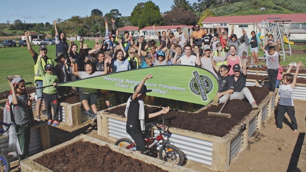 Children cheer on top of raised garden beds