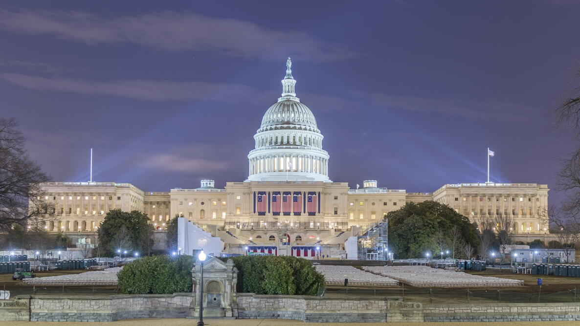 The West side of the US Capitol Building as it is prepared for the 58th presidential inauguration ceremony. The platform has been created and four of the five flags have been hung.
