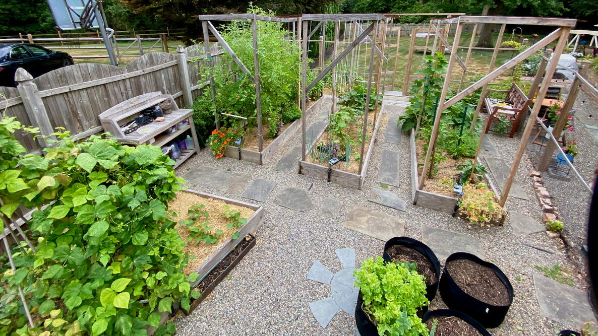Neat rows of raised garden beds, with gravel and stone walkways