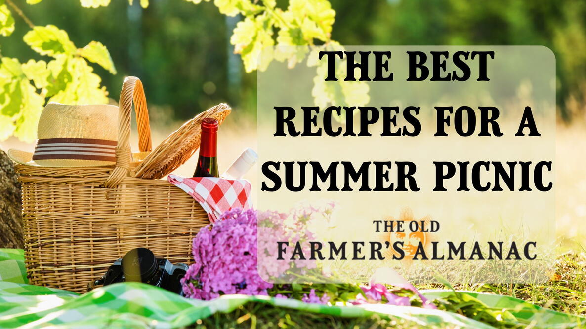 The best recipes for a summer picnic. picnic basket on a blanket with a hat and bottle of wine