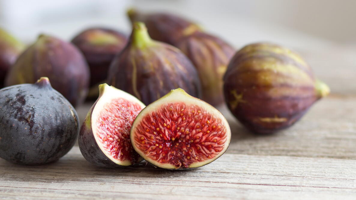 fig fruit on a table, one cut open