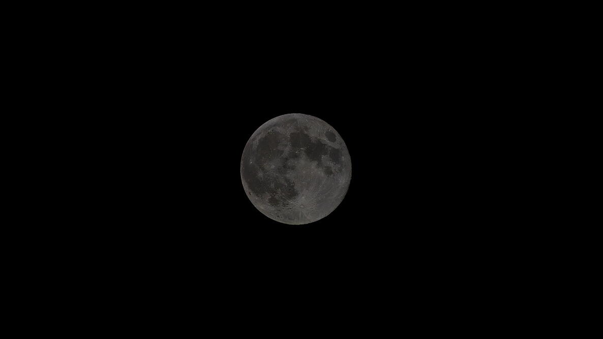 The near side of the moon at night as seen from earth with a dark background