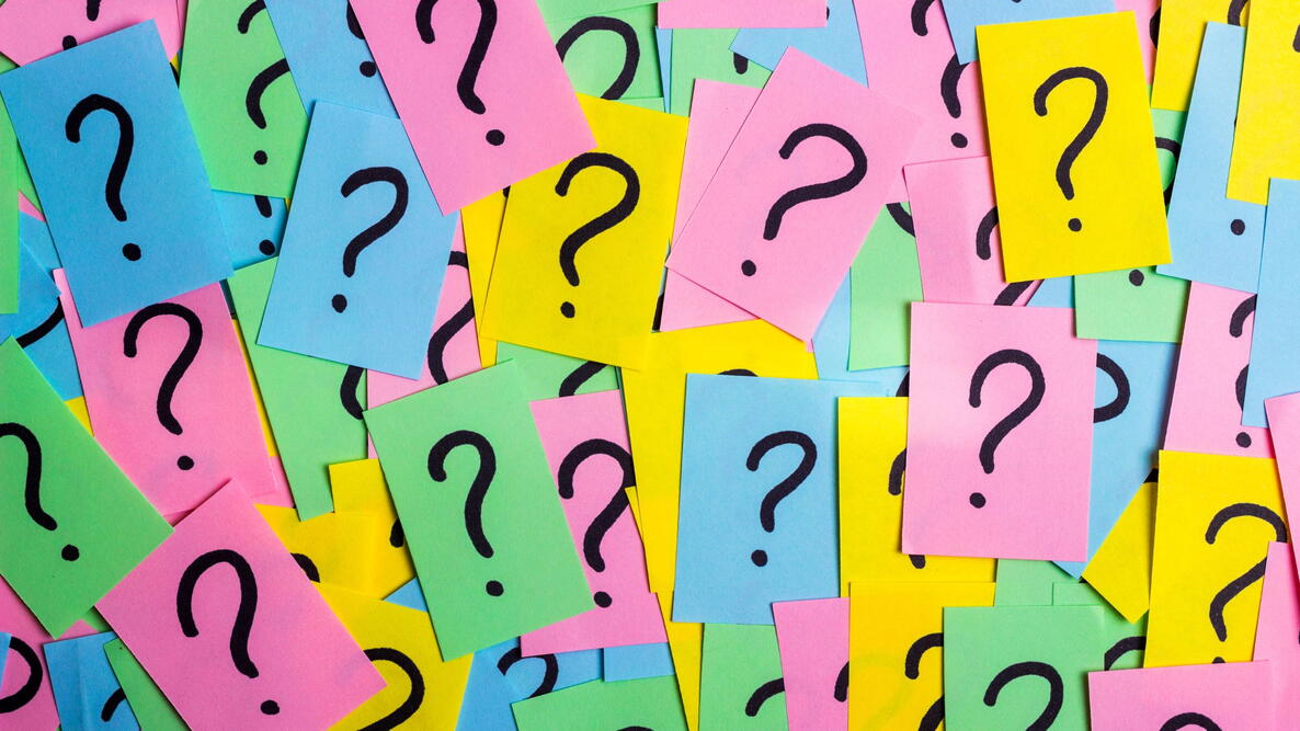 black question marks on neon sticky notes