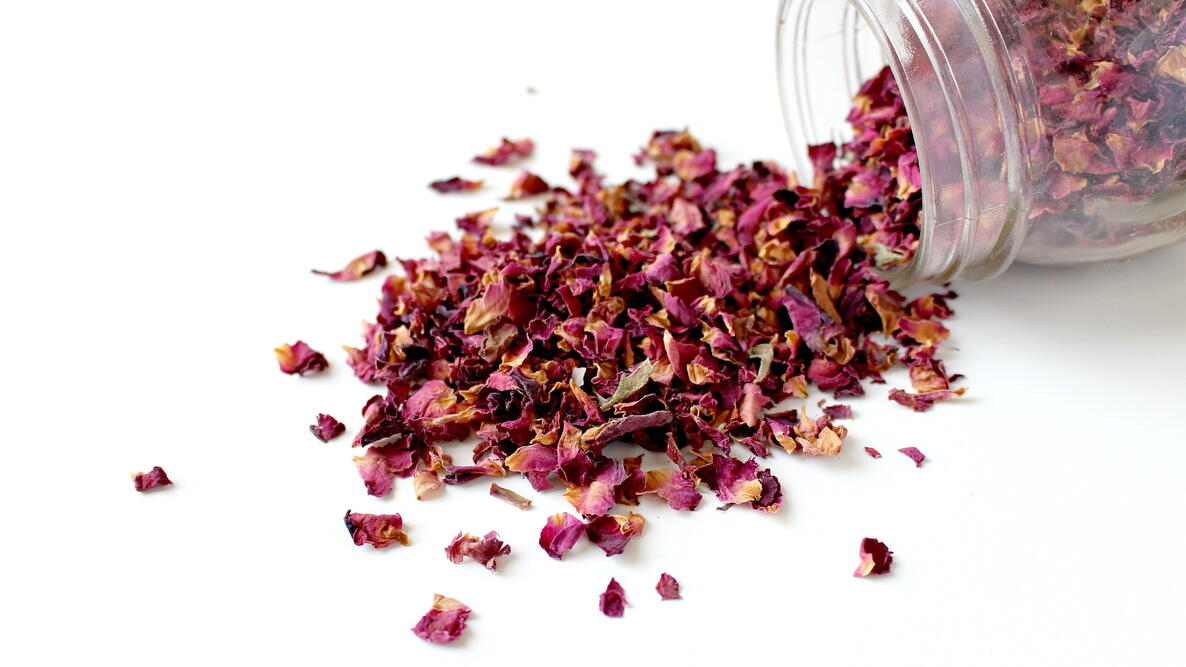 rose potpourri spilling out of a glass jar