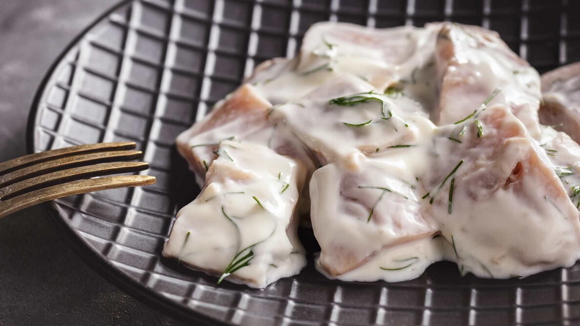 Pickled herring in cream sauce with dill.