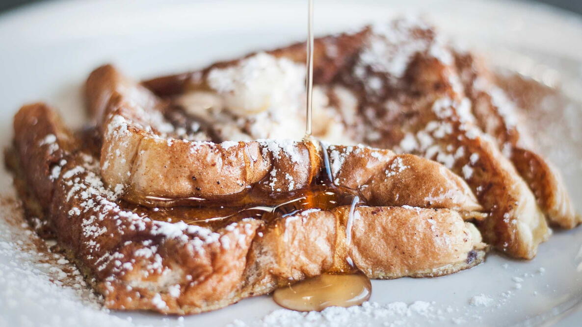 French Toast with Syrup and powdered sugar on a white plate
