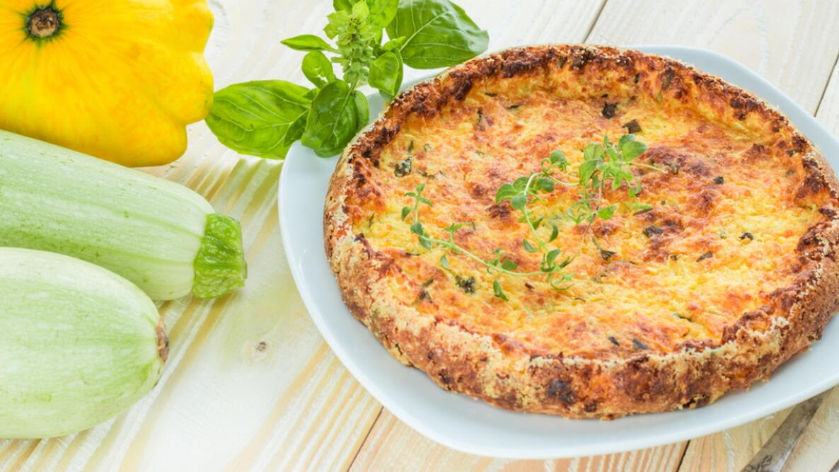 casserole from zucchini with thyme and old silver cutlery on wooden table