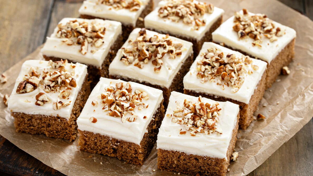 tomato spiced cake bars with cream cheese frosting and pecan nuts