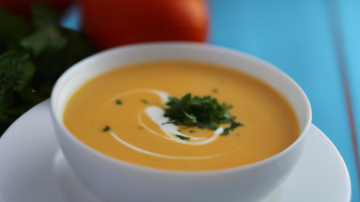 a bowl of turnip soup with parsley on a table in a white bowl