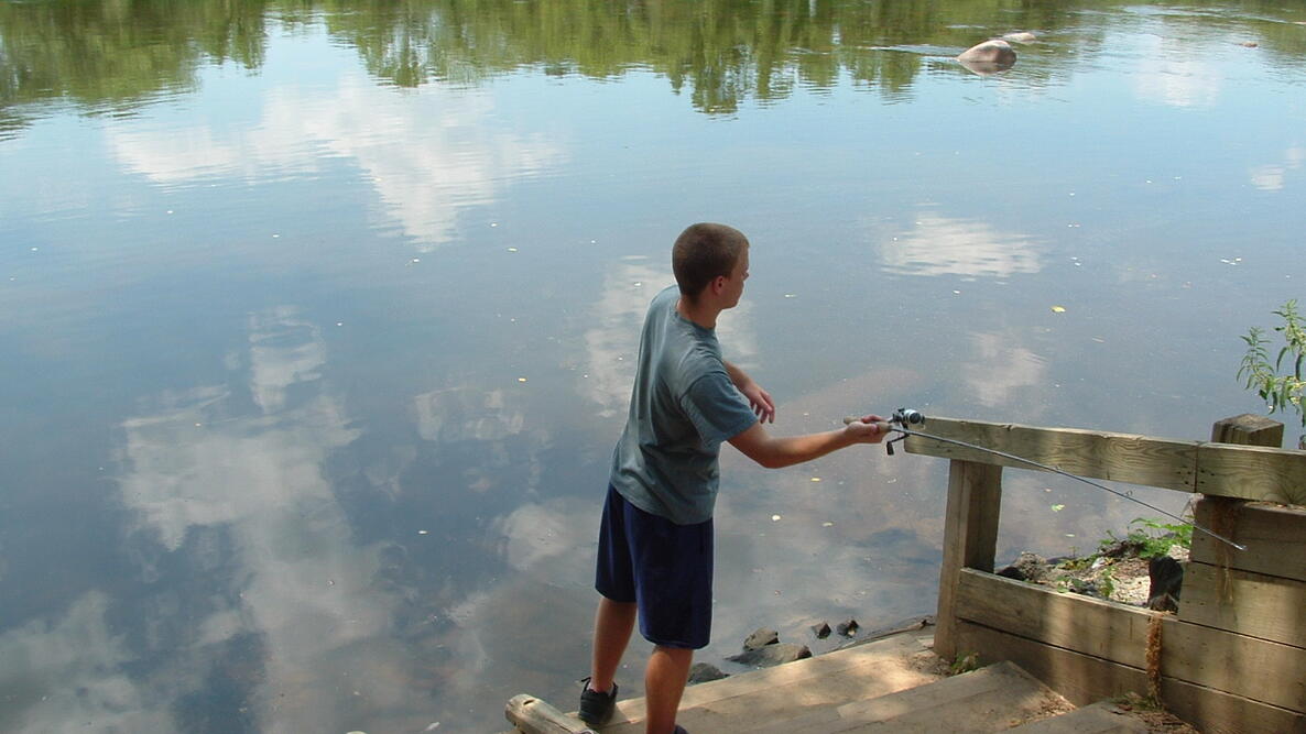 young man fishing on the shore of the James River