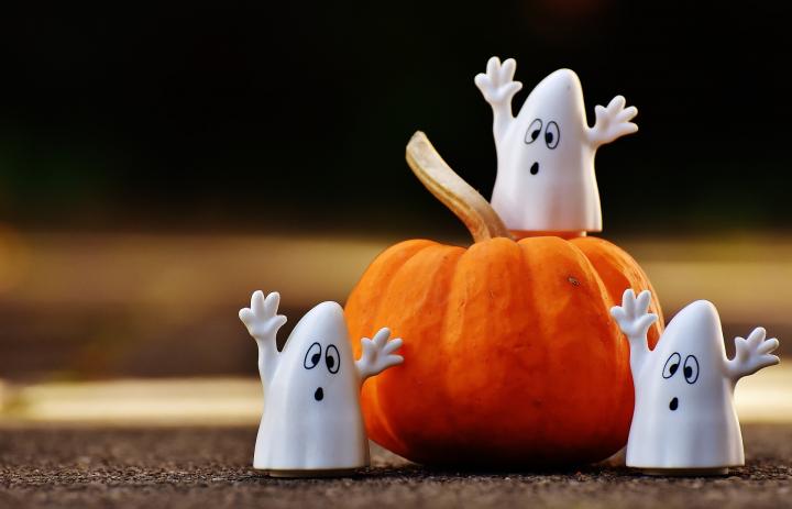 cute ghost figurines on a pumpkin